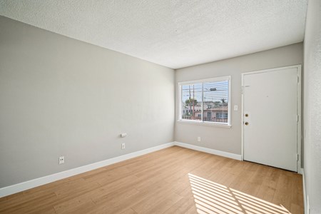 Empty room with wooden floor and white walls.
